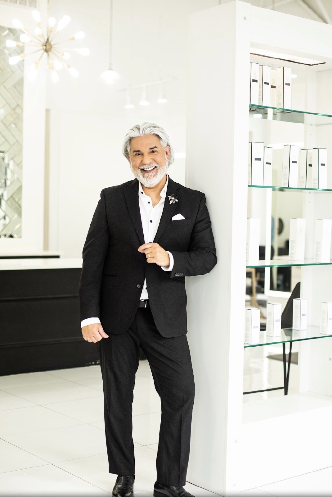 Charles beside the glass retail display — professional products on lit shelves